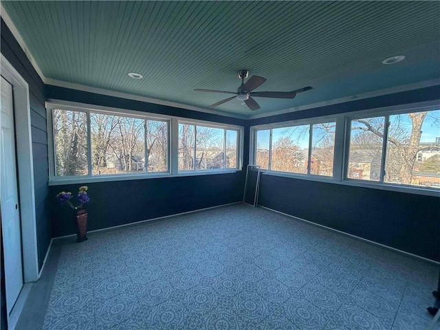 unfurnished sunroom with a ceiling fan