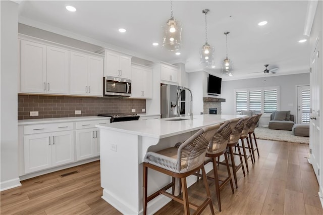 1768 Evenstad Way, Smyrna, GA 30080 - kitchen with appliances with stainless steel finishes, a sink, open floor plan, a ceiling fan, and a kitchen island with sink