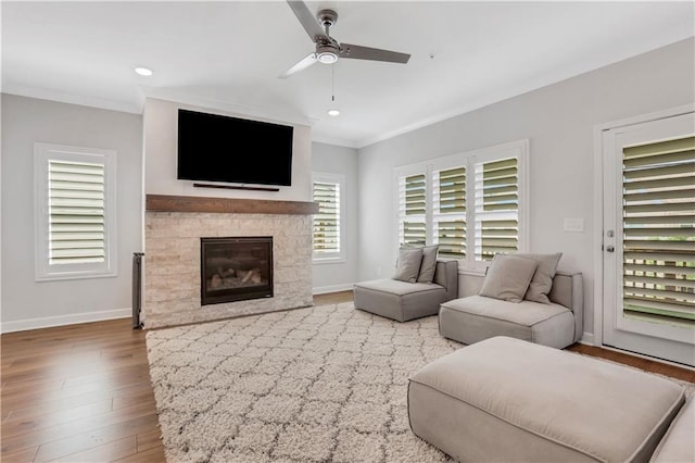 1768 Evenstad Way, Smyrna, GA 30080 - living room featuring wood finished floors, crown molding, a ceiling fan, baseboards, and a glass covered fireplace