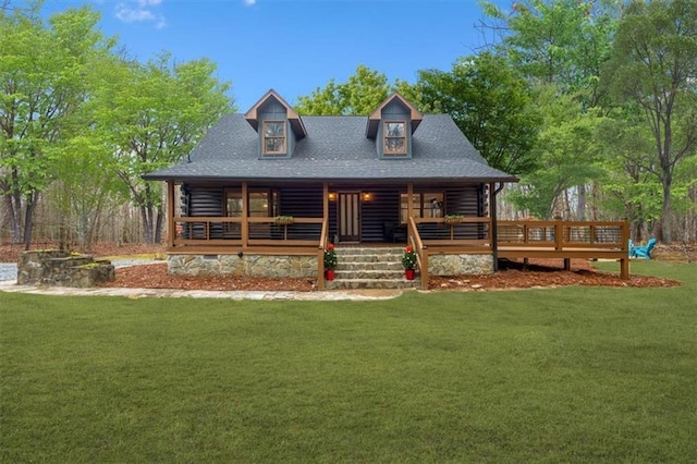 view of front facade featuring a front lawn, a porch, roof with shingles, and log exterior