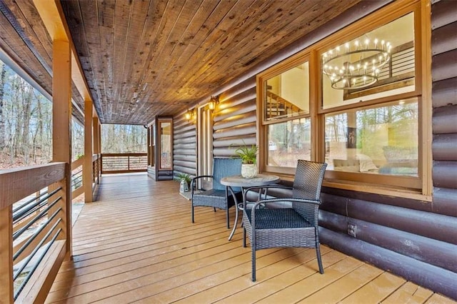 sunroom / solarium with wooden ceiling, a wealth of natural light, and a notable chandelier