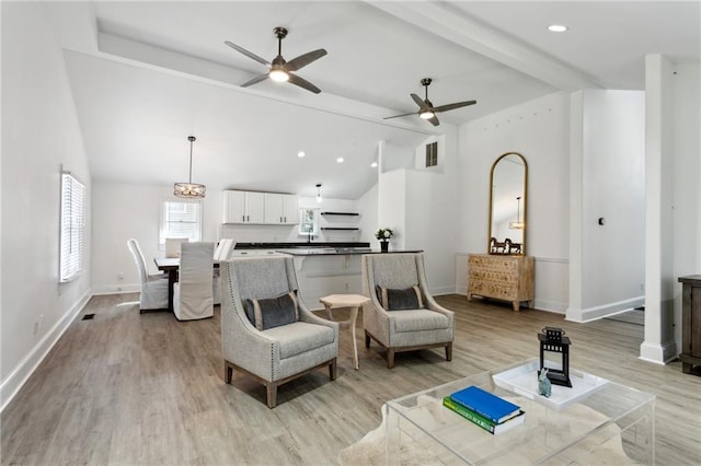 living room featuring beamed ceiling, ceiling fan, high vaulted ceiling, and light wood-type flooring