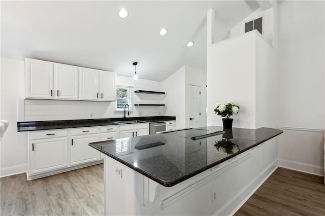 kitchen with white cabinetry, sink, dark stone countertops, stainless steel dishwasher, and black electric cooktop