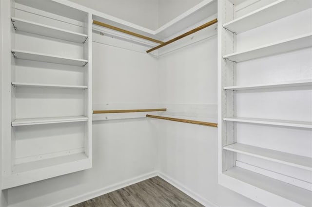 walk in closet with dark hardwood / wood-style floors