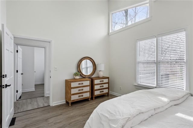 bedroom with wood-type flooring and a high ceiling