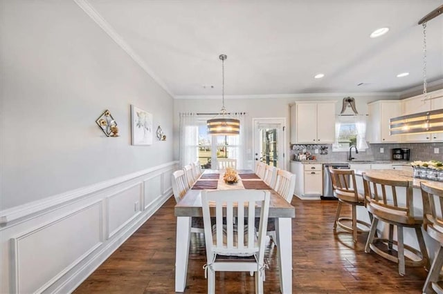 dining area featuring crown molding, a wainscoted wall, recessed lighting, a decorative wall, and dark wood-style flooring