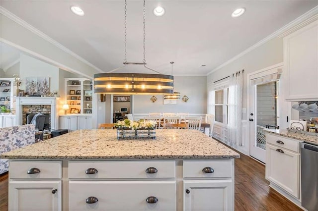 kitchen with a kitchen island, crown molding, dishwasher, a fireplace, and white cabinets