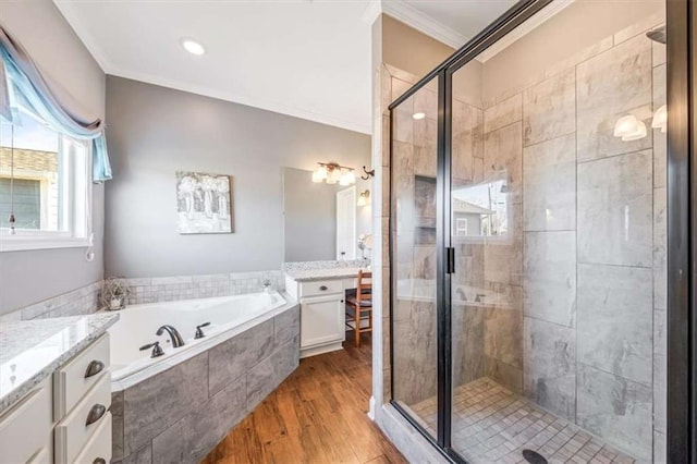 full bathroom featuring vanity, wood finished floors, a stall shower, ornamental molding, and a garden tub