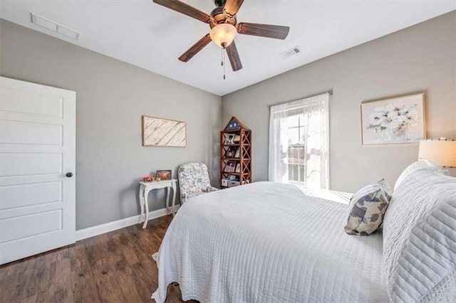 bedroom featuring visible vents, a ceiling fan, baseboards, and wood finished floors