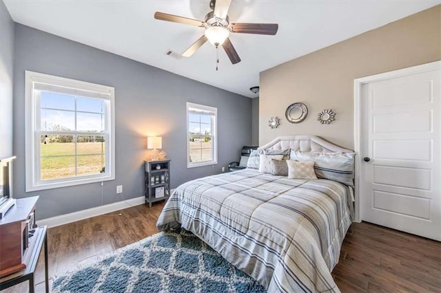 bedroom with ceiling fan, baseboards, and wood finished floors