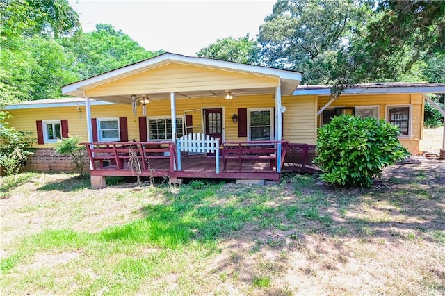 view of front of house featuring ceiling fan and a front yard