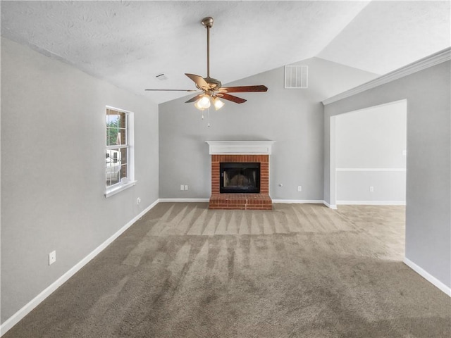 unfurnished living room with visible vents, lofted ceiling, ceiling fan, carpet floors, and a brick fireplace