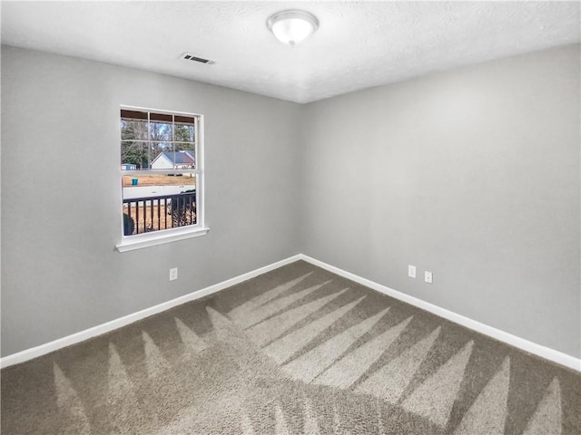 carpeted spare room featuring visible vents, a textured ceiling, baseboards, and stairs