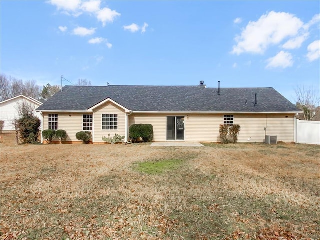 back of property with central AC, a lawn, fence, and roof with shingles