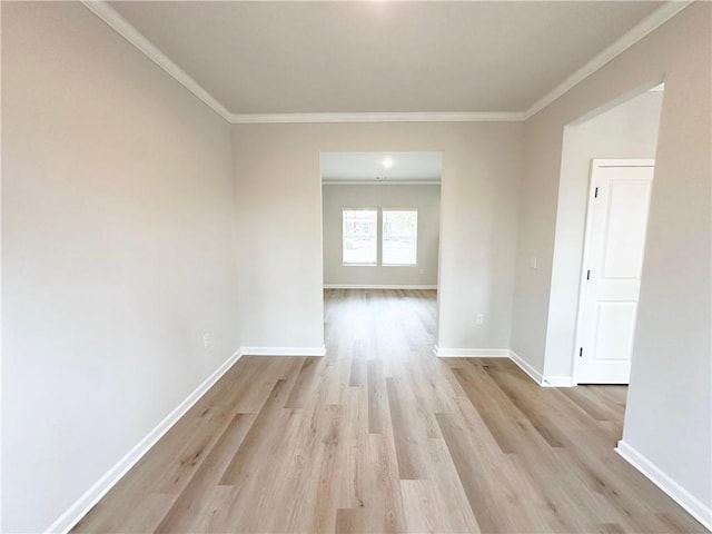 unfurnished room featuring baseboards, light wood-style floors, and crown molding