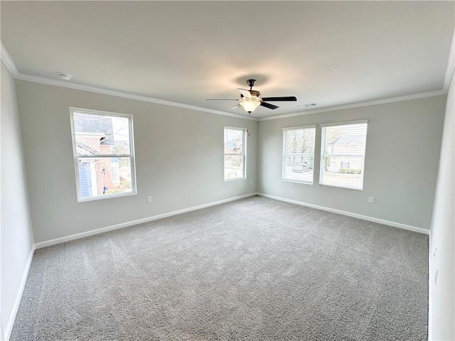 carpeted empty room with visible vents, baseboards, ceiling fan, and crown molding