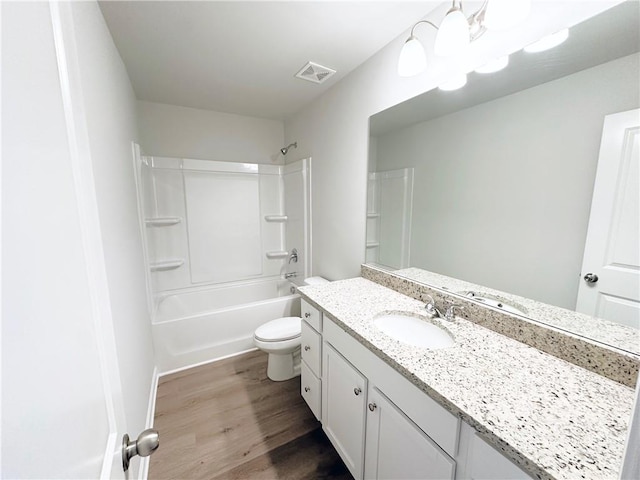 bathroom featuring vanity, wood finished floors, visible vents, bathtub / shower combination, and toilet