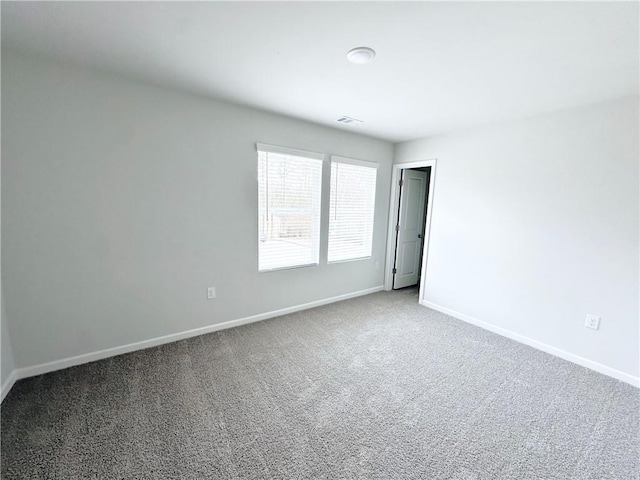 unfurnished room with baseboards, carpet floors, and visible vents