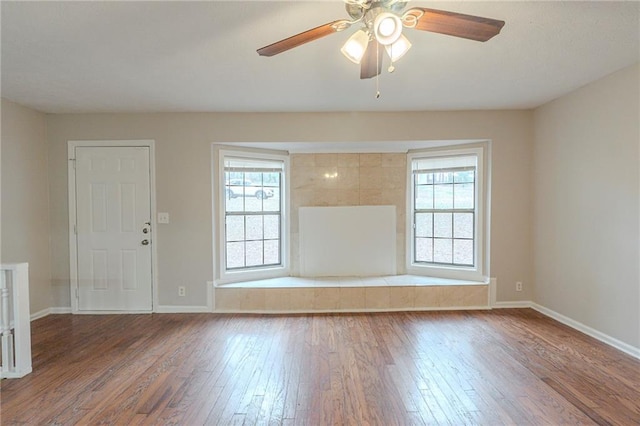 unfurnished room featuring hardwood / wood-style flooring, plenty of natural light, and ceiling fan