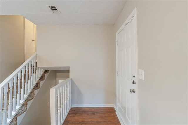 hallway featuring dark hardwood / wood-style floors and a textured ceiling