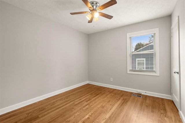 empty room with a textured ceiling, ceiling fan, and light wood-type flooring