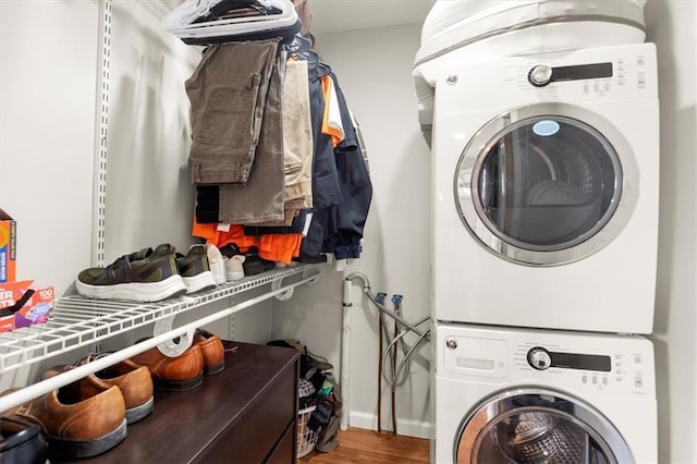 washroom with wood-type flooring and stacked washer and clothes dryer