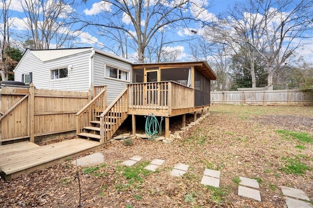 rear view of property with a sunroom and a deck