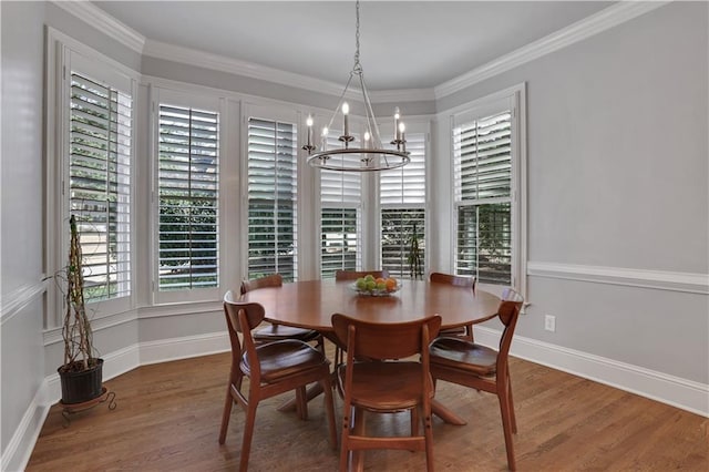 dining room with crown molding, wood finished floors, baseboards, and a chandelier