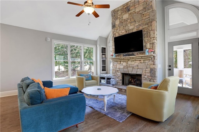 living area with wood finished floors, baseboards, a ceiling fan, high vaulted ceiling, and a fireplace