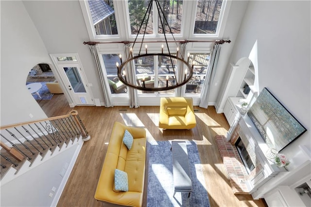 living room with baseboards, a chandelier, stairway, a towering ceiling, and wood finished floors