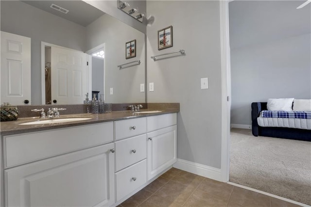 bathroom with tile patterned flooring, visible vents, double vanity, and a sink