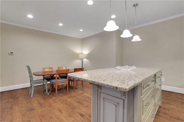 kitchen featuring baseboards, a kitchen island, light wood-style flooring, recessed lighting, and crown molding