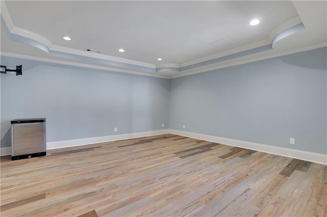 unfurnished room featuring a tray ceiling, light wood-style flooring, recessed lighting, and baseboards