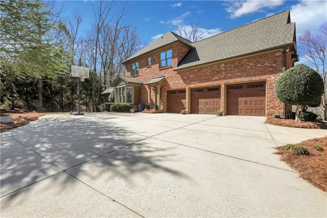 view of front of home with an attached garage, brick siding, driveway, and roof with shingles