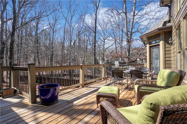 deck featuring outdoor dining area, a grill, and outdoor lounge area