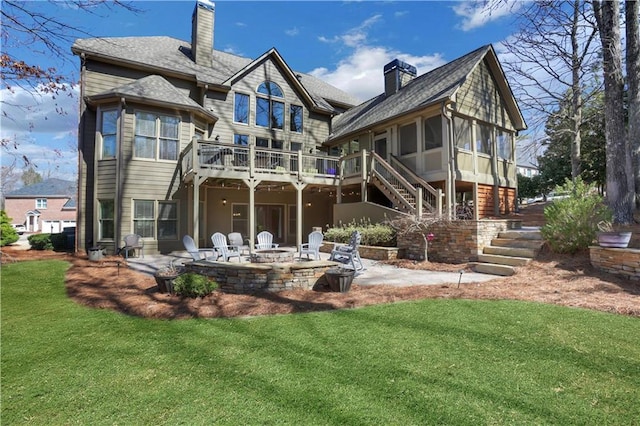 back of house featuring stairway, a sunroom, a chimney, and a patio area