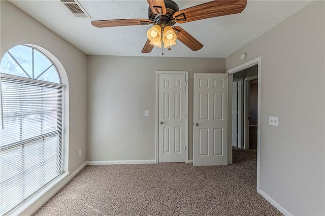 unfurnished bedroom featuring ceiling fan and carpet flooring