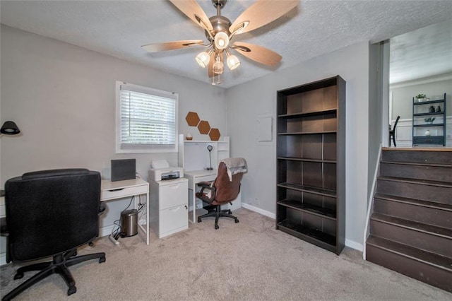 office featuring ceiling fan, light colored carpet, and a textured ceiling