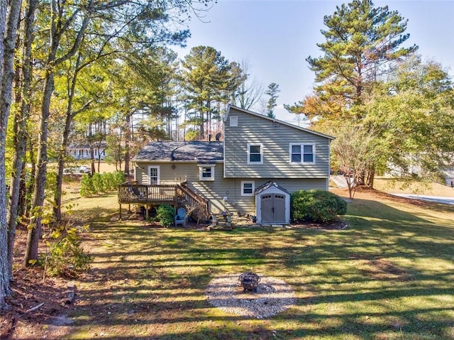 back of house with an outdoor fire pit, a yard, a deck, and a storage shed