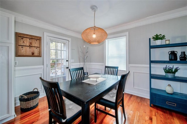 dining room featuring ornamental molding and light hardwood / wood-style floors