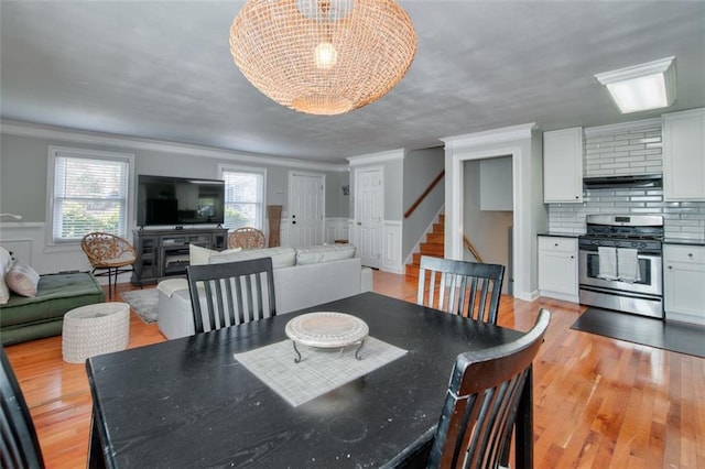 dining area featuring crown molding and light wood-type flooring