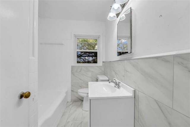 bathroom featuring vanity, toilet, and tile walls