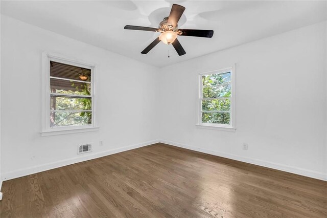 spare room featuring dark hardwood / wood-style flooring, plenty of natural light, and ceiling fan