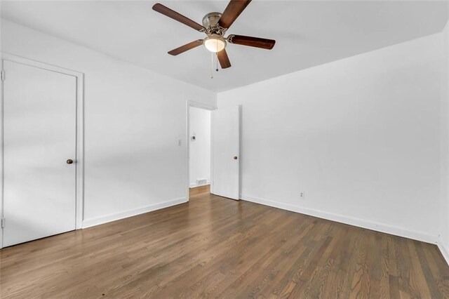 unfurnished room with ceiling fan and dark hardwood / wood-style flooring