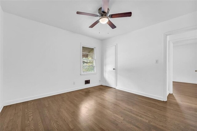 spare room featuring ceiling fan and dark wood-type flooring