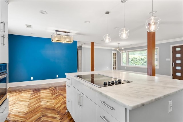 kitchen with pendant lighting, ornamental molding, black electric stovetop, and white cabinetry