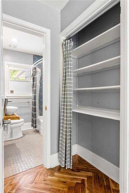 bathroom featuring baseboards and toilet