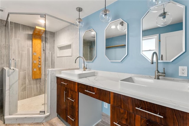 full bathroom featuring a sink, a shower stall, and double vanity