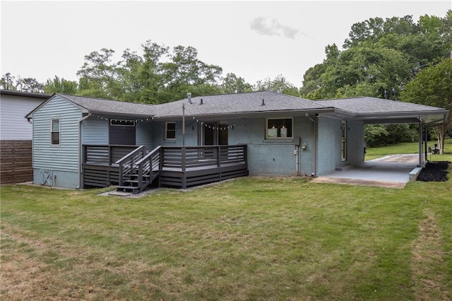 rear view of house featuring brick siding, a wooden deck, a yard, and an attached carport