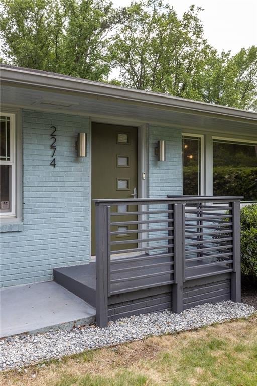 property entrance with brick siding and a porch